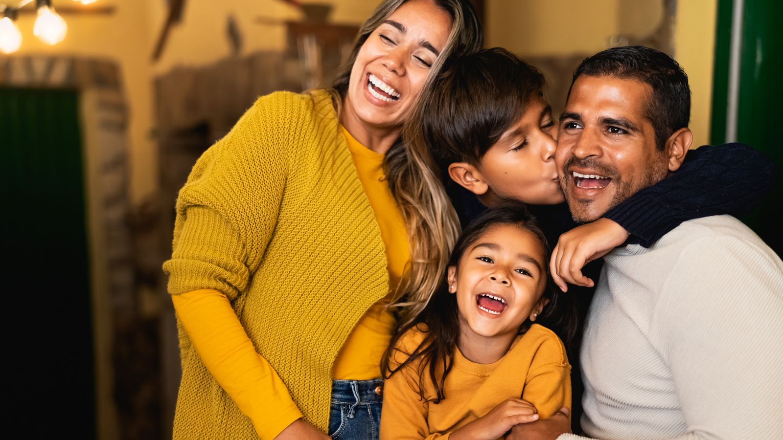 A family of four laughing together at home