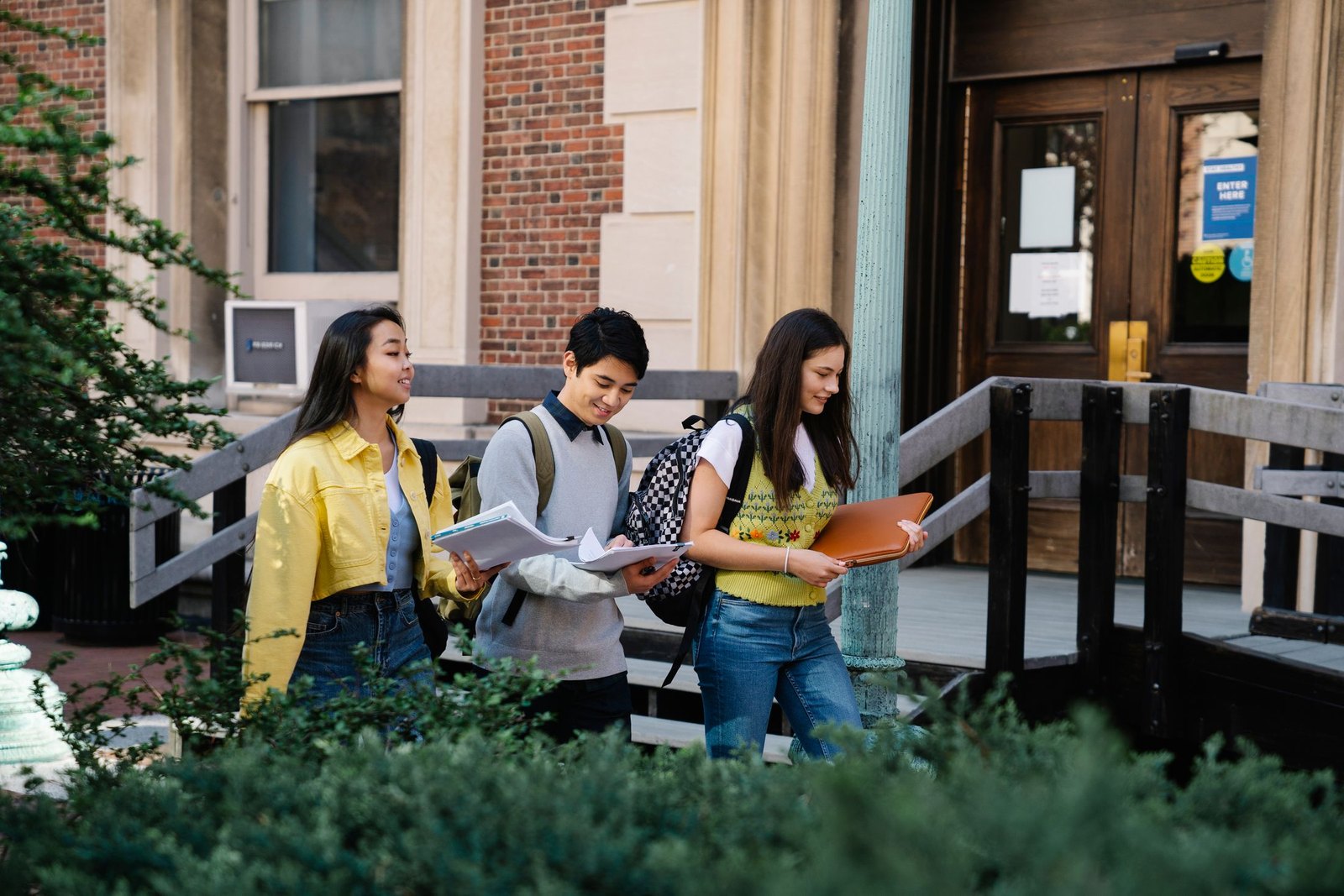 College students carrying books outside a university building