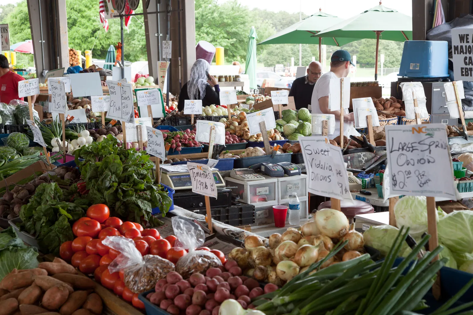 People browsing produce at a farmers market in Raleigh, North Carolina